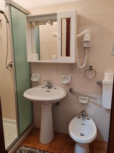 a bathroom with a sink and a toilet at Hotel Triestina in Noli