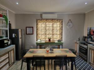 KarooSjiek Self-catering في Adendorp: مطبخ مع طاولة وكراسي ونافذة
