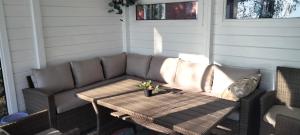a couch and a table on a patio at Nelikko juhla- ja majoitustilat in Himanka