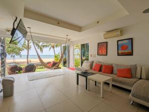 a living room with a couch and a table at Beachfront Magic Villa - by KohChangVillas in Ko Chang