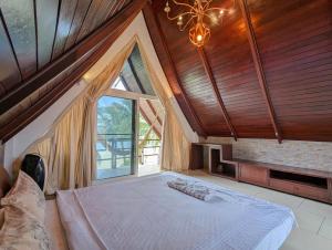 a large bedroom with a large bed and a large window at Beachfront Magic Villa - by KohChangVillas in Ko Chang