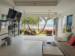 a living room with a view of the beach at Beachfront Magic Villa - by KohChangVillas in Ko Chang +16 photos