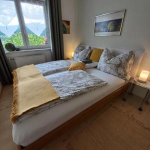 ein großes Bett in einem Zimmer mit Fenster in der Unterkunft Ferienwohnung Energie Oase in Millstatt