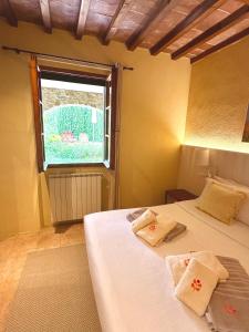 um quarto com 2 camas e uma janela em Relais Poggio Del Melograno em Montecatini Val di Cecina