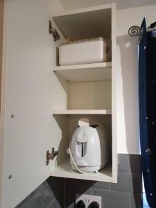 a kitchen cupboard with a white appliance in it at Glorioushome in Basildon