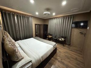a bedroom with a large bed and a television in it at Lidder view Resorts in Pahalgām