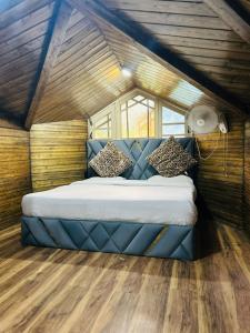 a bedroom with a blue bed in a room at Lidder view Resorts in Pahalgām