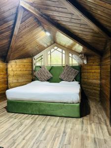 a bedroom with a large bed in a wooden room at Lidder view Resorts in Pahalgām