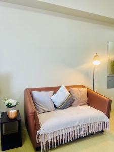 a brown couch with pillows on it in a room at City Charm FASTWifi, Netflix, Queen Bed in Cagayan de Oro +28 photos