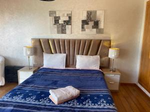 1 dormitorio con 1 cama con sábanas azules y 2 lámparas en Belle-Vue sur Mer à Casa-Marina 9éme étage en Casablanca