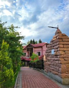 una pasarela de ladrillo frente a una casa rosa en Glory en Truskavets
