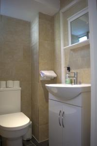 La salle de bains est pourvue de toilettes blanches et d'un lavabo. dans l'établissement Horizon, à Brighton et Hove