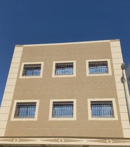 丹吉爾的住宿－Appart Hicham，一座高大的建筑,上面有四扇窗户