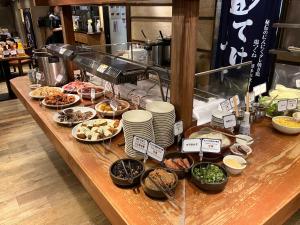 ein Buffet mit vielen verschiedenen Speisen auf dem Tisch in der Unterkunft Nishitetsu Inn Shinjuku in Tokio