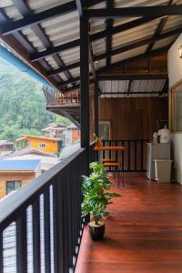 einen Balkon eines Hauses mit einer Pflanze darauf in der Unterkunft ไชยพล โฮมสเตย์ หมู่บ้านแม่กำปอง in Ban Pok Nai