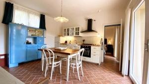 a kitchen with a wooden table and chairs at La Tonnaia in Lari