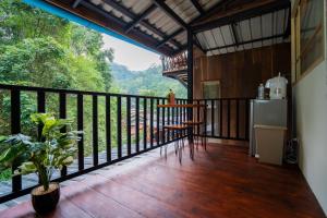 uma varanda de uma casa com uma mesa e um frigorífico em ไชยพล โฮมสเตย์ หมู่บ้านแม่กำปอง em Ban Pok Nai