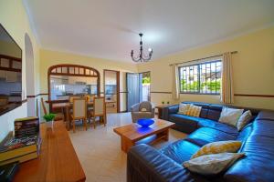 ein Wohnzimmer mit einem blauen Sofa und einem Tisch in der Unterkunft 2 Bed Ground Floor Apartment In Vilamoura in Vilamoura