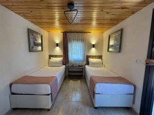 Le Petit Hotel ve Bağ Evi في بوزجادا: غرفة بسريرين في غرفة