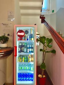 a refrigerator filled with bottles of soda and a plant at Hotel Sara in Milan