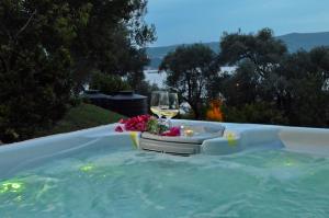 a glass of wine and flowers in a hot tub at Boka View by Roši in Tivat