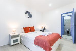 a white bedroom with a bed and a mirror at Vita Portucale ! Costa Caparica Harmony in Costa da Caparica