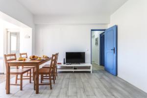 a dining room with a table and chairs and a tv at Vita Portucale ! Costa Caparica Harmony in Costa da Caparica