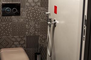 a bathroom with a toilet and a door with a camera at Senses Violett Suites - Adults Only in Zell am See