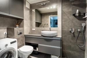 une salle de bain avec un lavabo et une machine à laver dans l'établissement Apartament Batorego 7 z parkingiem, à Gdynia 36 autres photos