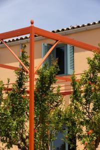 an orange metal structure in front of a building with trees at La Segreta Country House Planeta in Menfi