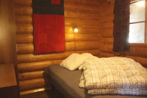 a bedroom with a bed in a log cabin at Koivurannan Lomamökit Mänty in Nykälä
