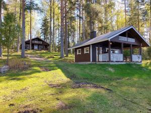 a small cabin in the woods with a yard at Koivurannan Lomamökit Mänty in Nykälä