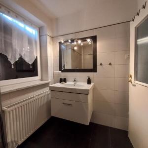 ein weißes Badezimmer mit einem Waschbecken und einem Spiegel in der Unterkunft Ferienwohnung Energie Oase in Millstatt