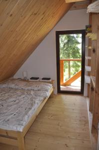 a bedroom with a bed and a large window at Cataleya Rajcza in Rajcza