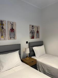 a bedroom with two beds and two paintings on the wall at Christellie Luxury Apartment in Kiáton