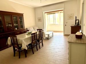 una cucina e una sala da pranzo con tavolo e sedie di Donizetti Vacation Apartment a Porto Cesareo