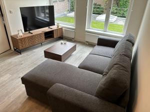 uma sala de estar com um sofá e uma televisão em The Residence Deventer em Deventer