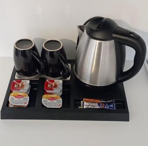 a black and silver tea pot and cups on a tray at Studio Eleni in Plomari