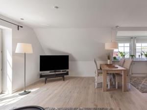 a living room with a television and a table with chairs at Giselas Ferienwohnung Ostsee in Holzstein in Oldenburg in Holstein
