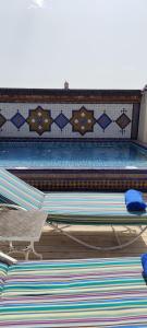 una piscina con due letti e un tavolo di Riad Dar Saad - Hammam & Spa a Marrakech