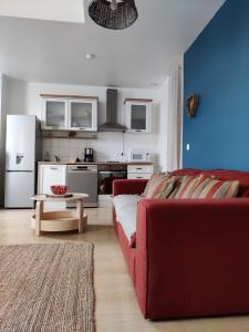 sala de estar con sofá rojo y cocina en Au Saule Pleureur, en Villers-Saint-Paul