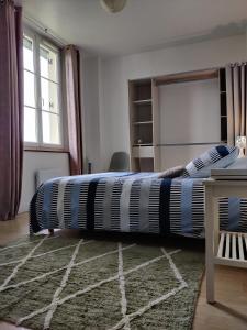1 dormitorio con 1 cama grande con alfombra en Au Saule Pleureur, en Villers-Saint-Paul