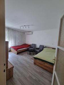 a bedroom with two beds and chairs in it at Studio apartman Milla in Karlovac