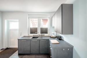 a kitchen with gray cabinets and a sink at Landpartie in Bestensee