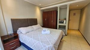 1 dormitorio con 1 cama con 2 toallas en Hotel Firenze en Necochea