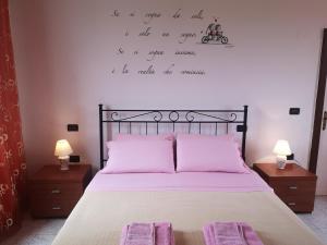 a bedroom with a bed with pink pillows and two lamps at B&B Stella dell'Adriatico in Ortona