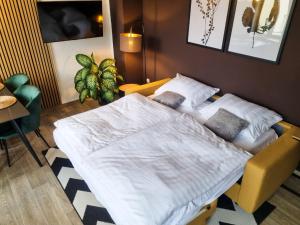 a bedroom with a bed and a chair and a table at maremar - Design Maisonette Altstadt - 4 Personen - Luxus Boxspringbett - Vollausstattung in Greiz