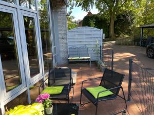 AmmersbekにあるFerienwohnungferienwohnungの家の上に椅子とベンチ付きのパティオ