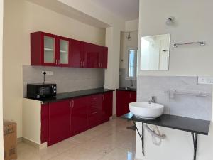a bathroom with red cabinets and a white sink at SSN Home Stays in Bangalore near PLAY Arena in Bangalore