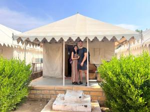 mężczyzna i kobieta stojący pod namiotem w obiekcie Rumis Desert Camp w mieście Jaisalmer